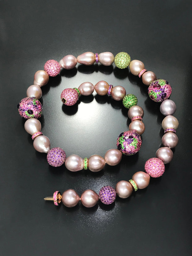 Natural color pink pearl strand with elements enhanced with a myriad of gemstones in 18 karat